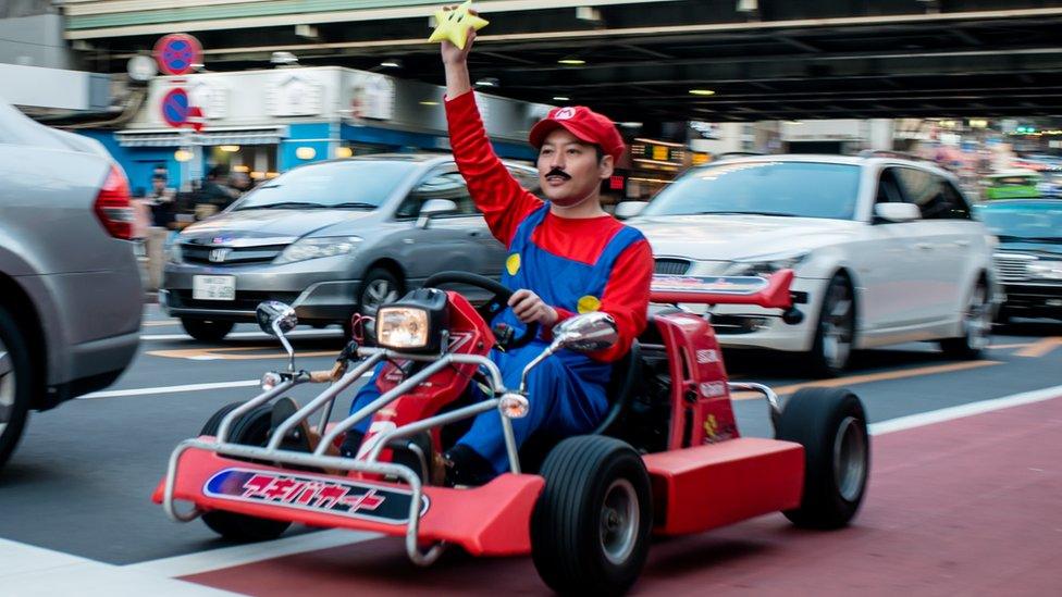 A driver dressed as Super Mario on a go-kart in Japan