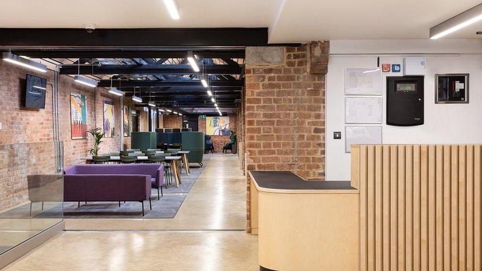 Modern reception area with purple sofas and wooden furniture