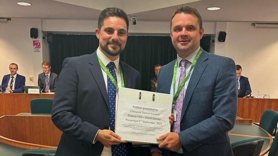 Conservative Councillor Tom Stowe (right) presented the petition to Liberal Democrat leader Joe Harris at the Cotswold District Council meeting on September 20.