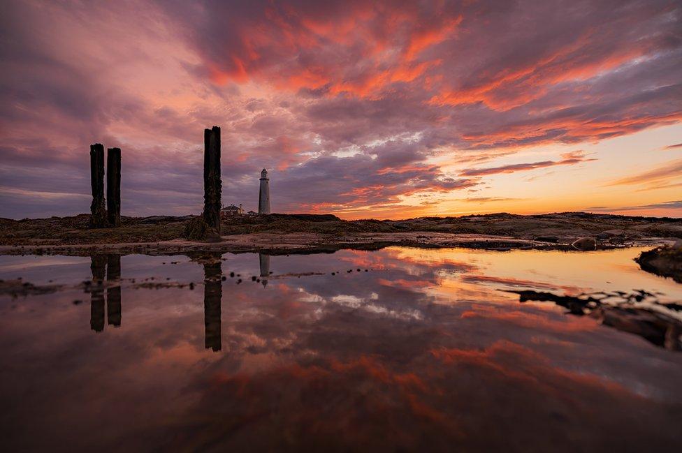 St Mary's Lighthouse reflected in water at sunrise