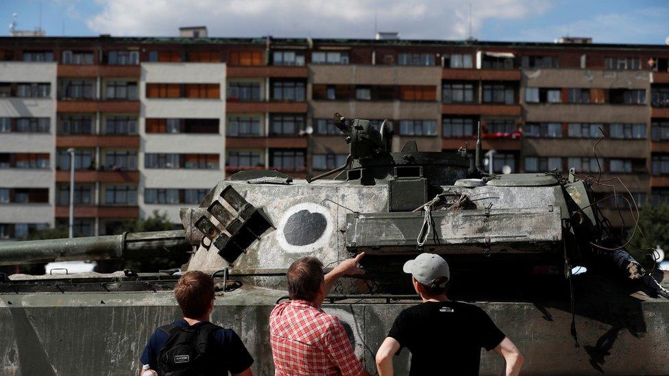 People look at a Russian tank on display in Prague