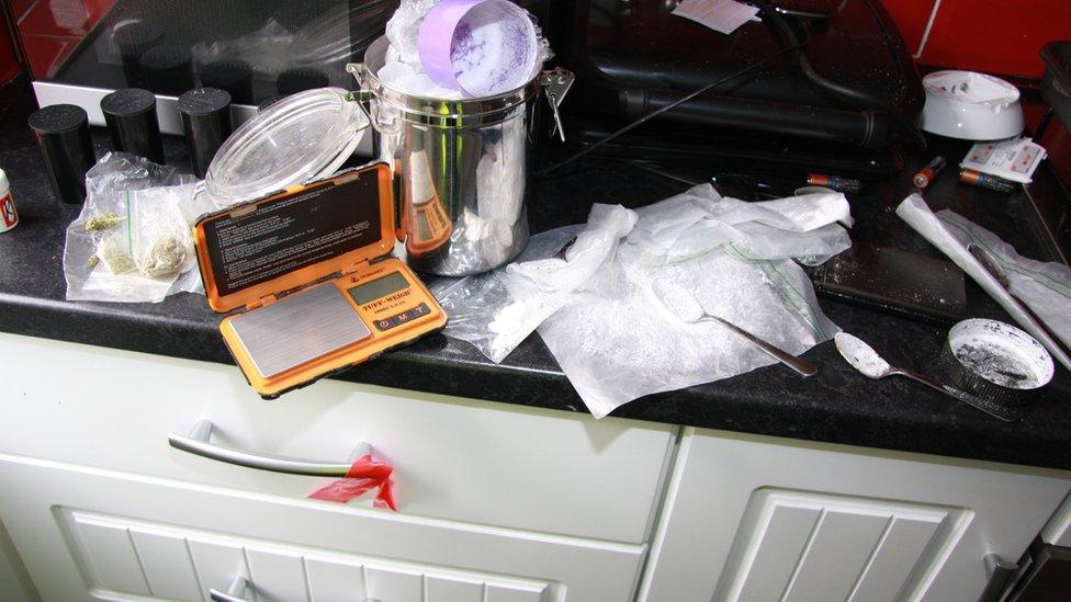 A bag of white powder, scales and cannabis on a kitchen unit