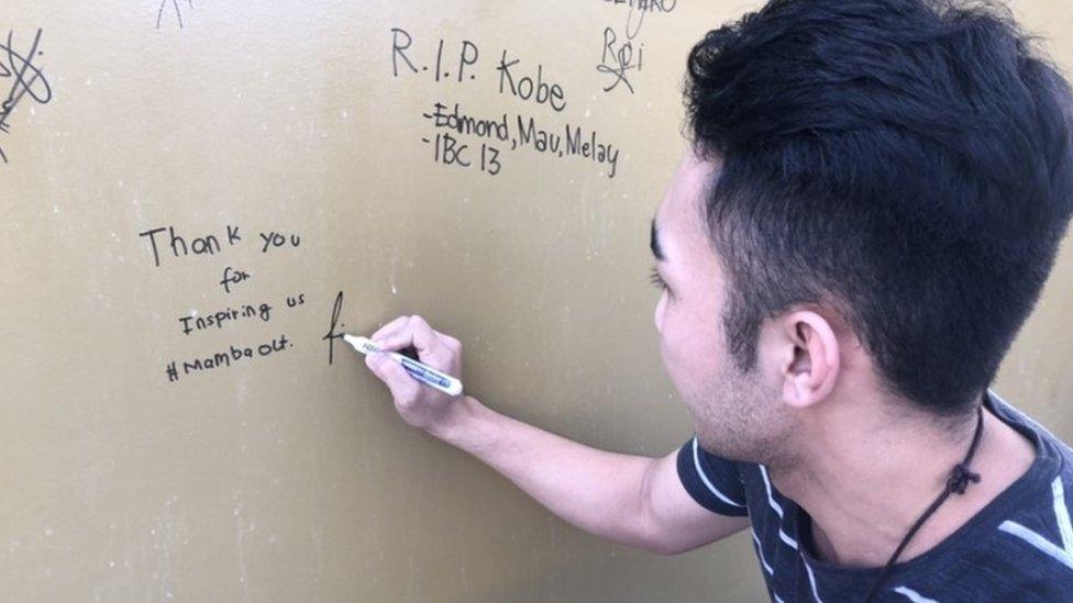 A fan writes a message to Kobe Bryant on the wall of the World of Kobe in Manila