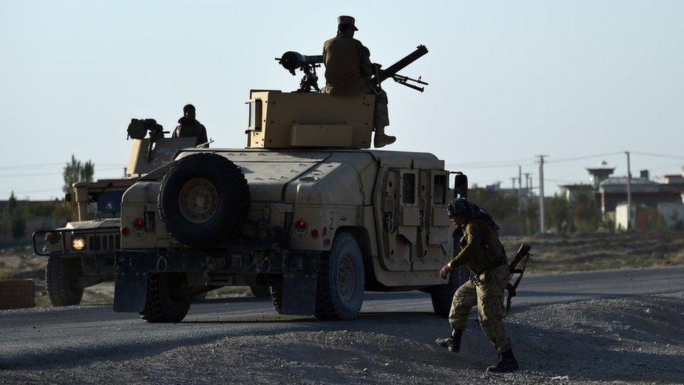 Afghan military personnel stand guard during fighting between Taliban militants and Afghan security forces in Kunduz on October 1, 2015.