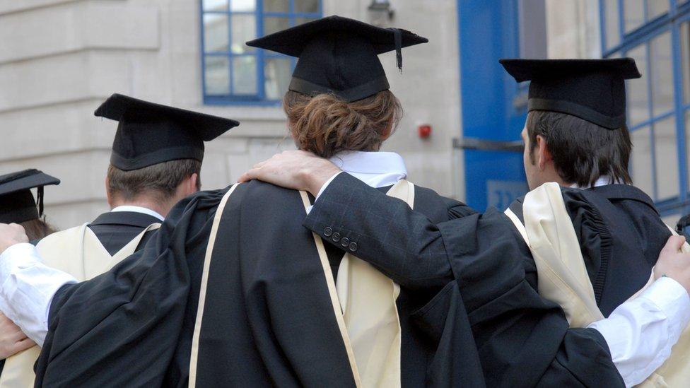 Graduates in robes and mortarboards outside their London university