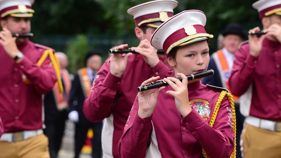 A girl plays a flute in a marching band at the Twelfth parade in Ballymena