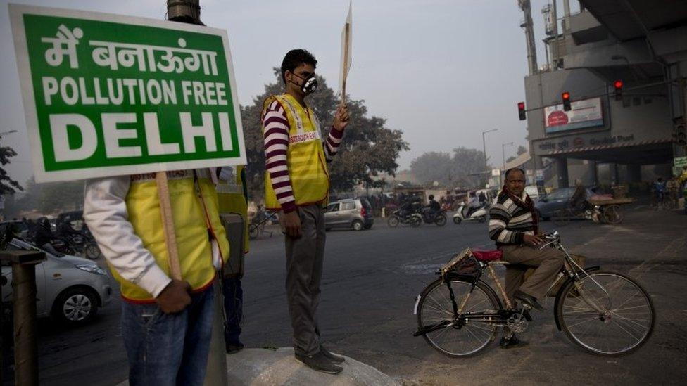 Volunteers display placards which read: "We will make a pollution free Delhi" during a two-week experiment to reduce the number of cars to fight pollution in New Delhi, India, Monday, Jan. 4, 2016.