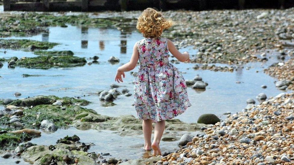 Little girl walking on a beach