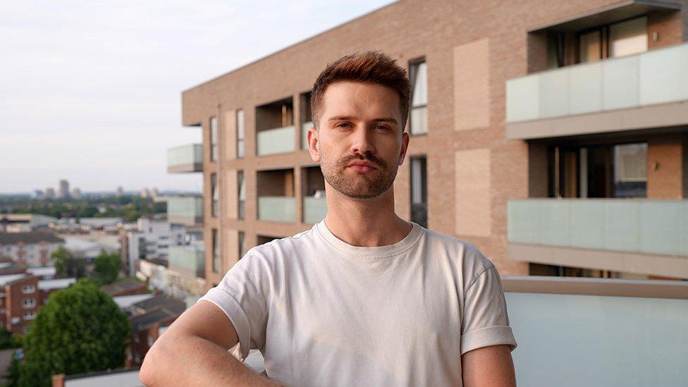 Sam standing on the balcony of his rented flat