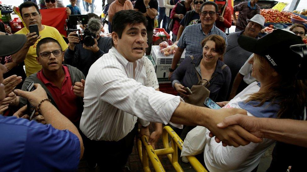 Carlos Alvarado Quesada greets people at a market on the campaign trail