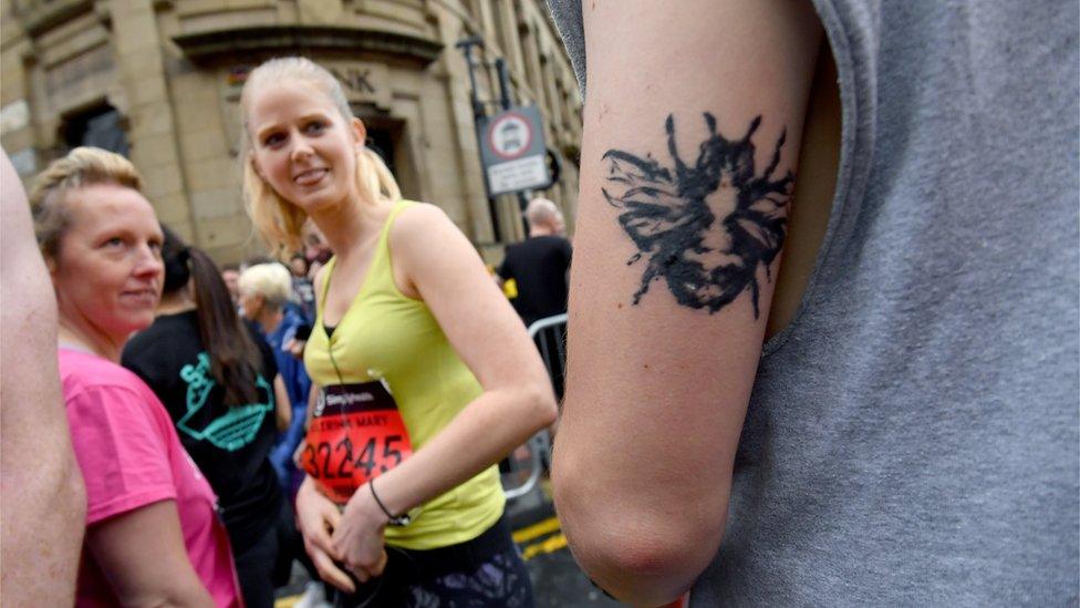 A runner shows off a bee design on his arm ahead of the start of the Great Manchester Run