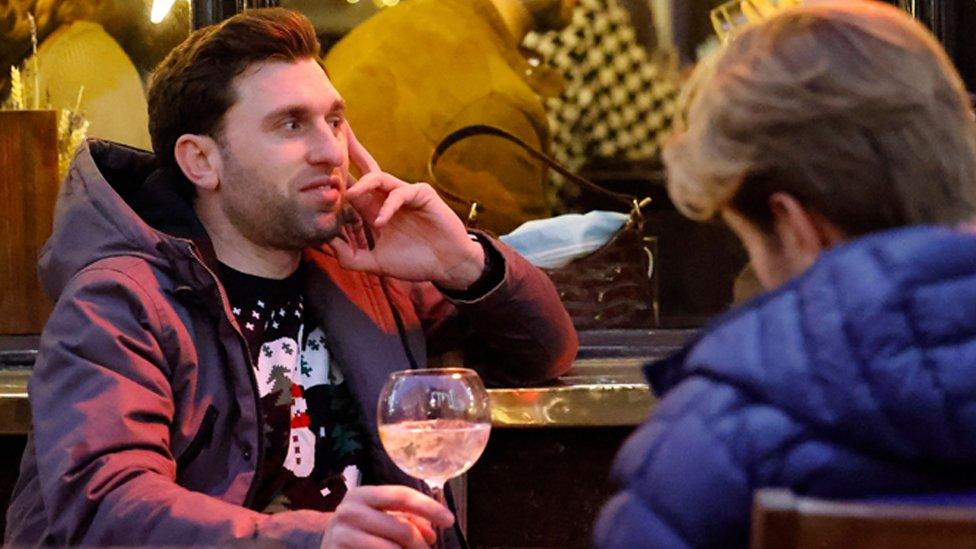 A man sits outside a pub