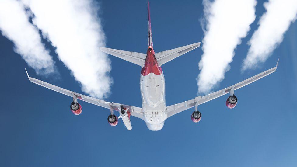 The LauncherOne rocket is carried aloft under the jumbo's port wing