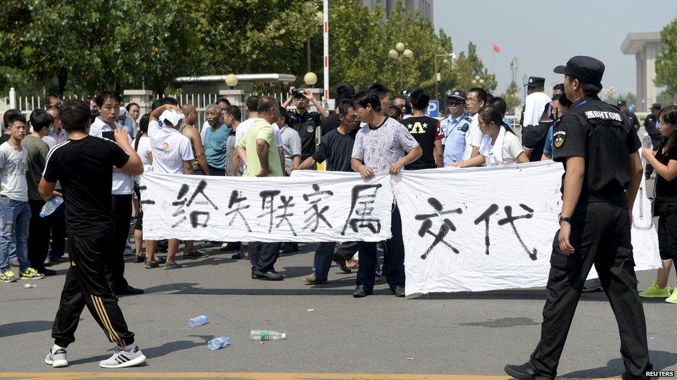 Relatives unfurl a banner during a protest to demand information about their relatives' whereabouts at Tianjin on 16 August 2015