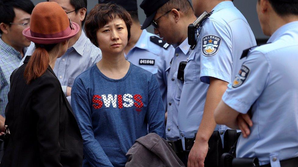 Policemen stand around Lin Ru, the wife of civil rights lawyer Xia Lin near the Beijing Number 2 People's Intermediate Court after her husband was sentenced to 12 years in prison on fraud charges in Beijing, China September 22, 2016