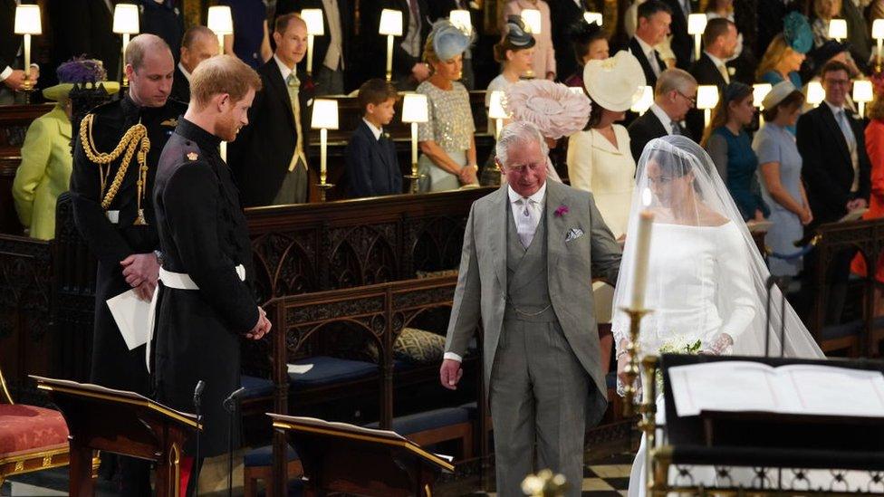 Prince Harry looks at his bride, Meghan Markle, as she arrives accompanied by Prince Charles, Prince of Wales during their wedding in St George's Chapel at Windsor Castle.