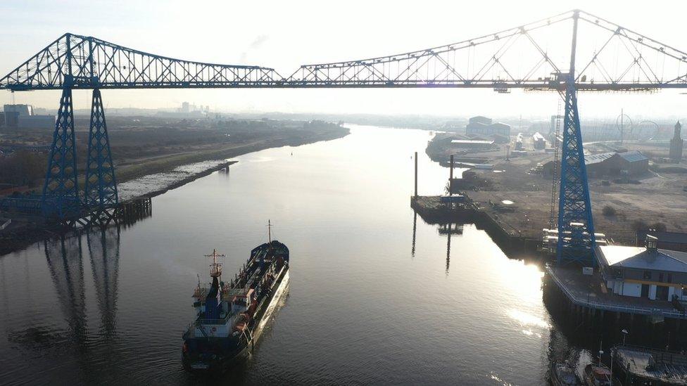 A dredger sails under the Transporter Bridge on the River Tees