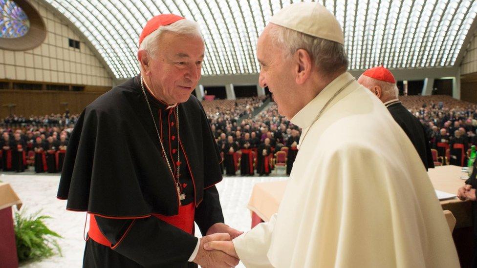 Cardinal Vincent Nichols (L) shakes hands with Pope Francis.