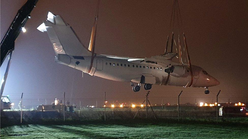 Avro RJ85 being lifted over road by cranes