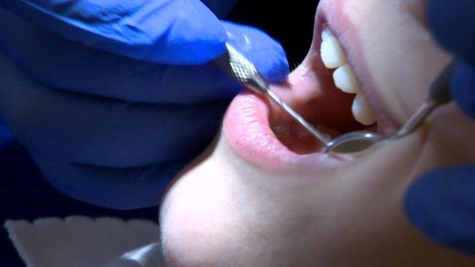 Dentist examines child's teeth