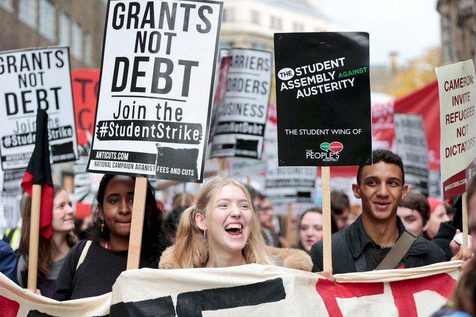 Students hold placards, and banners at the protest in London