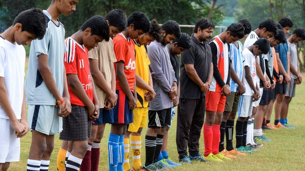 Young players observe a moment of silence to pay their tribute to Argentina's player Diego Maradona in Argentina