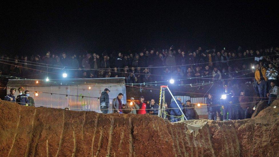 Bystanders watch as Moroccan authorities and firefighters work to rescue five-year-old boy Rayan, who is trapped in a deep well for over two days, near Bab Berred in Morocco's rural northern province of Chefchaouen on February 3, 2022.