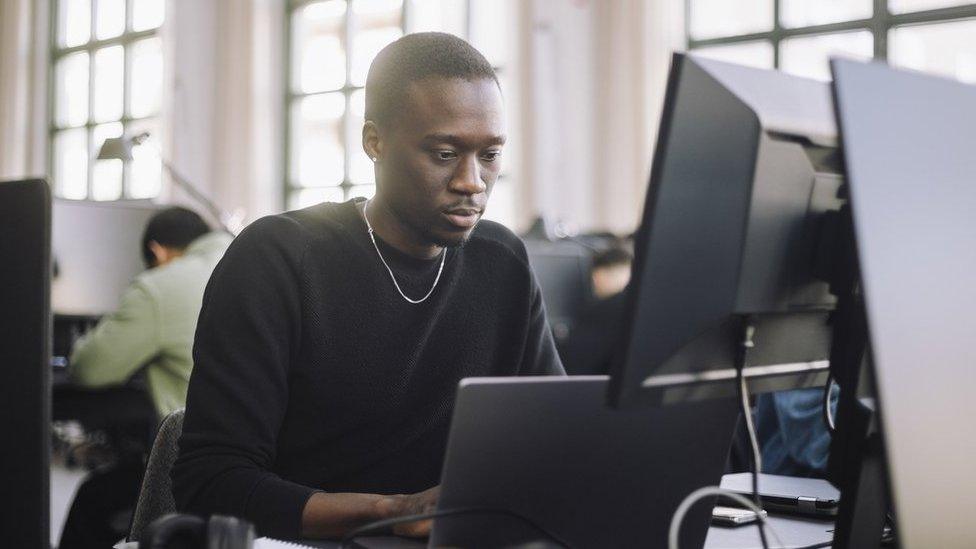 Stock image of a programmer working on a computer in an office