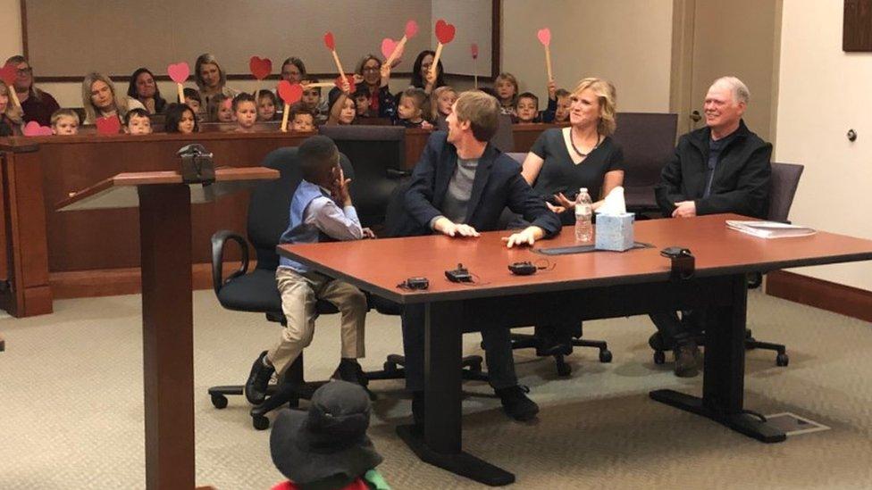 A picture shared by Kent County, Michigan's Facebook page shows a little boy named Michael being formally adopted in court, watched by his Kindergarten classmates