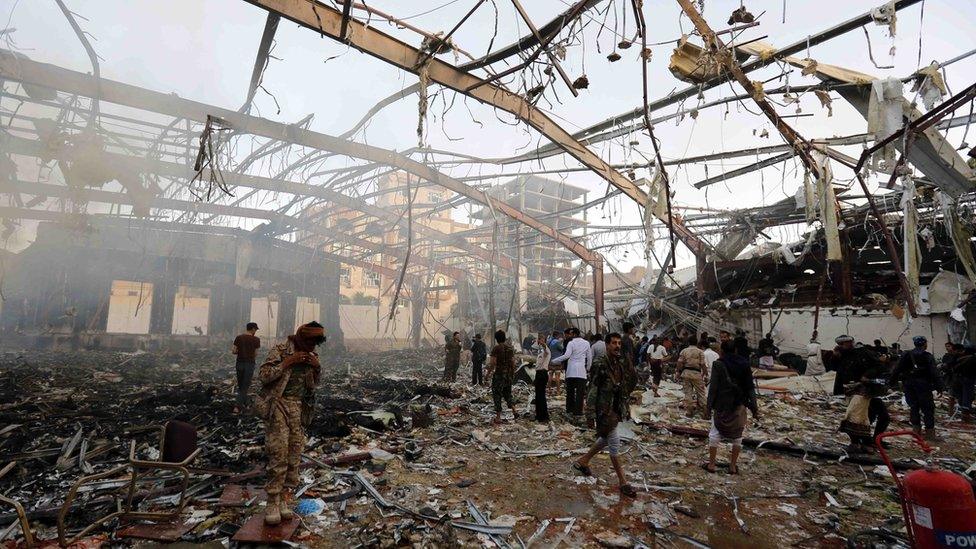 People inspect the aftermath of a Saudi-led coalition airstrike in Sanaa, Yemen, 8 October 2016