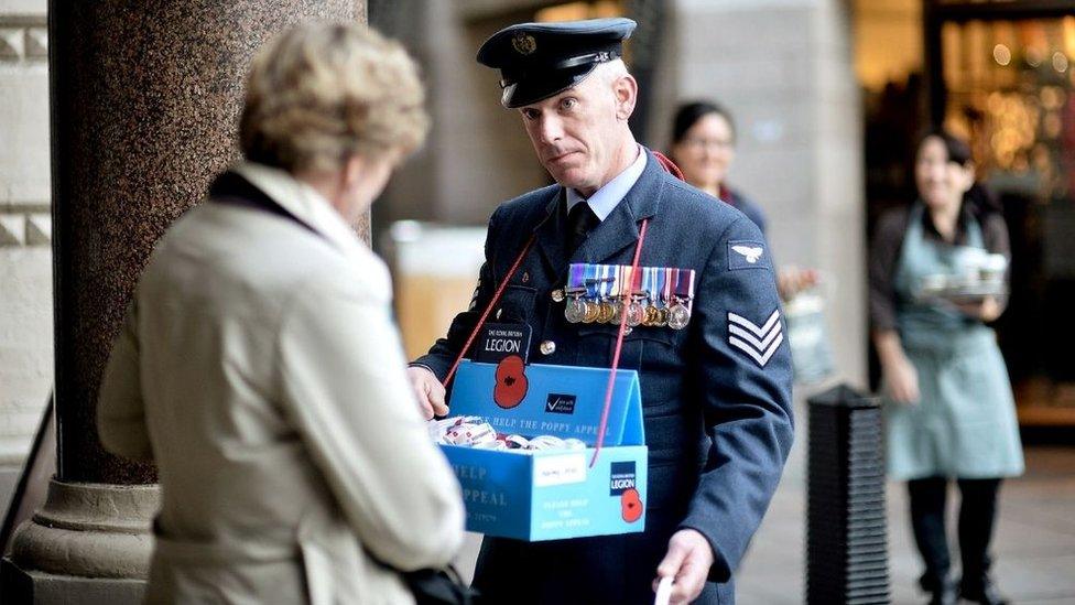 Member of the armed forces sell poppies