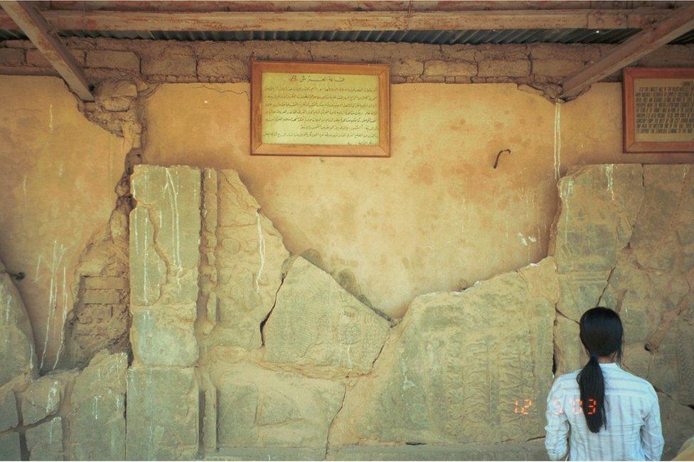 Woman looks at relief broken into fragments