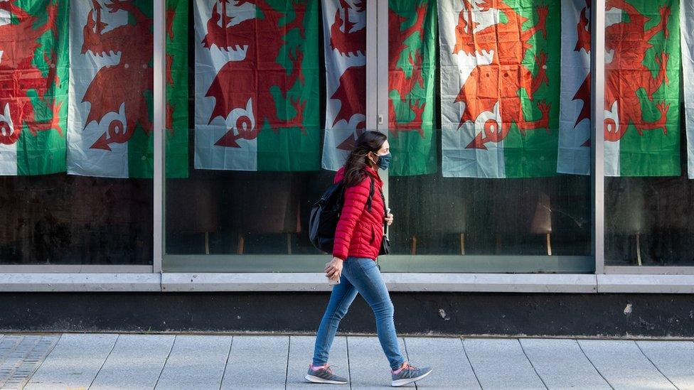 girl-walking-in-front-of-welsh-flag