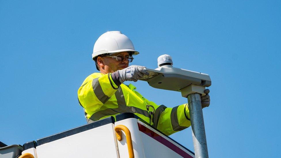 Man replacing street light