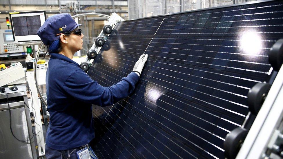 An employee makes a final inspection on panels during a tour of an REC solar panel manufacturing plant in Singapore, May 5, 2017.