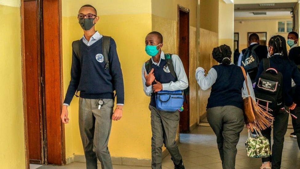 Students walking through a school corridor.