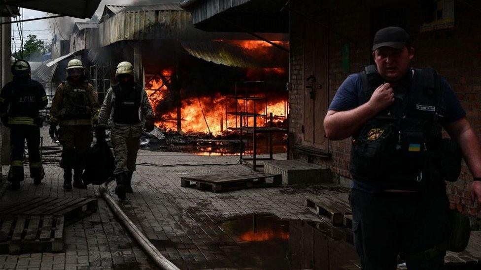 Firefighters work to control flames at the central market of Slovyansk on July 5, 2022,