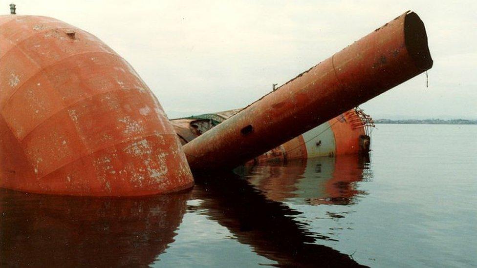 A large red and white leg from a platform floating