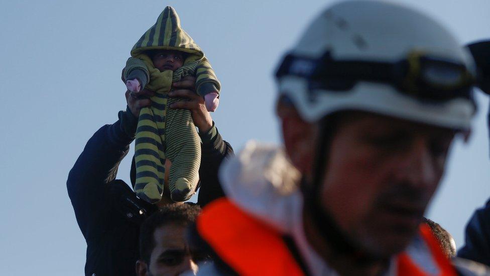 A 12-day-old Somali baby is lifted up by a migrant on a wooden boat during a rescue operation conducted by the Malta-based NGO Migrant Offshore Aid Station (MOAS) ship Phoenix in the central Mediterranean in international waters off the coast of Sabratha in Libya, April 15, 2017.