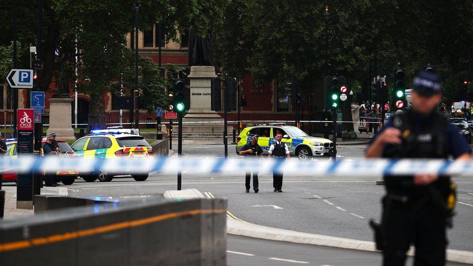 Armed police stand in the street after a car crashed outside the Houses of Parliament in Westminster, London