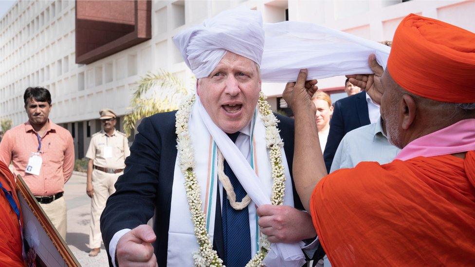 Prime Minister Boris Johnson having a turban placed on his head at Gujarat Bio Technology University, as part of his two day trip to India. Picture date: Thursday April 21, 2022.