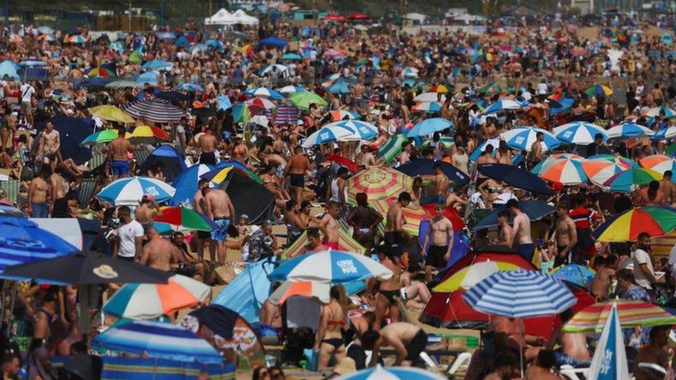 People and children enjoy the hot weather at Bournemouth Beach on June 17