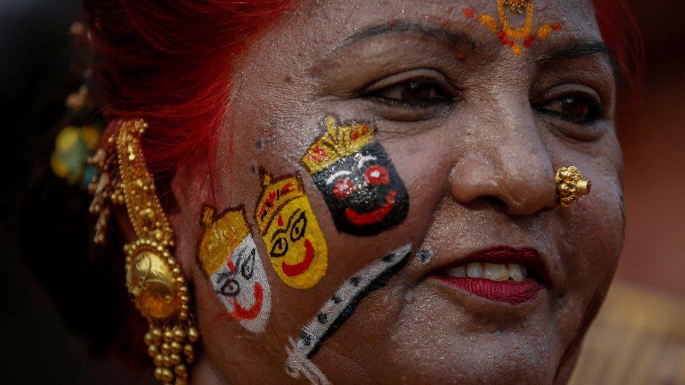 A Hindu devotee with the face painted with the images of Hindu Lord Jagannath, his brother Balabhadra and sister Subhadra, during the annual Rath Yatra, or chariot procession, in Ahmedabad, India