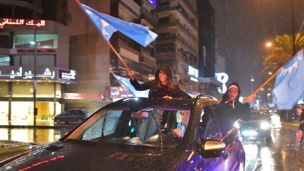 Supporters of Lebanese Prime Minister Saad Hariri wave flags as they celebrate his return to Beirut