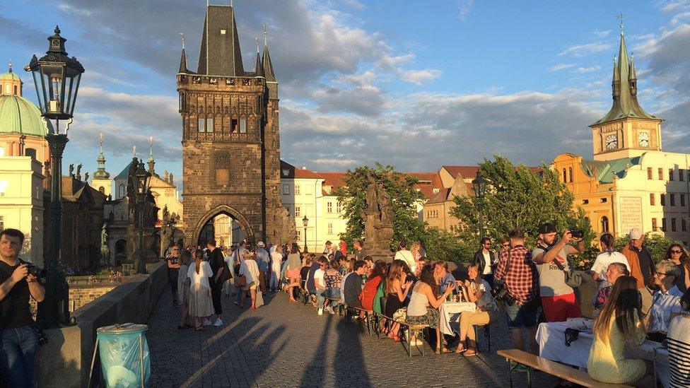 Residents dine at a long table set in Prague