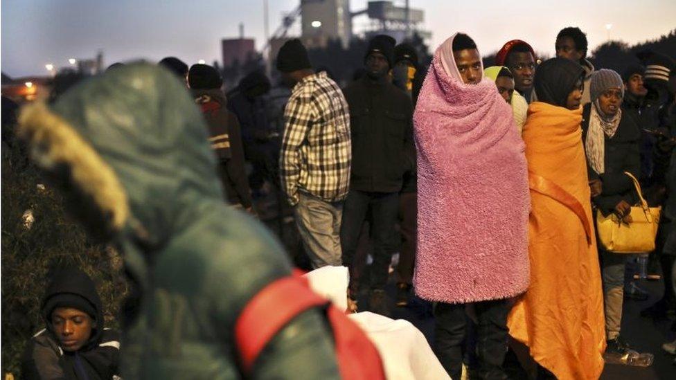 Migrants wait to register outside a processing centre in the makeshift migrant camp known as "the jungle" near Calais, northern France, on 27 October