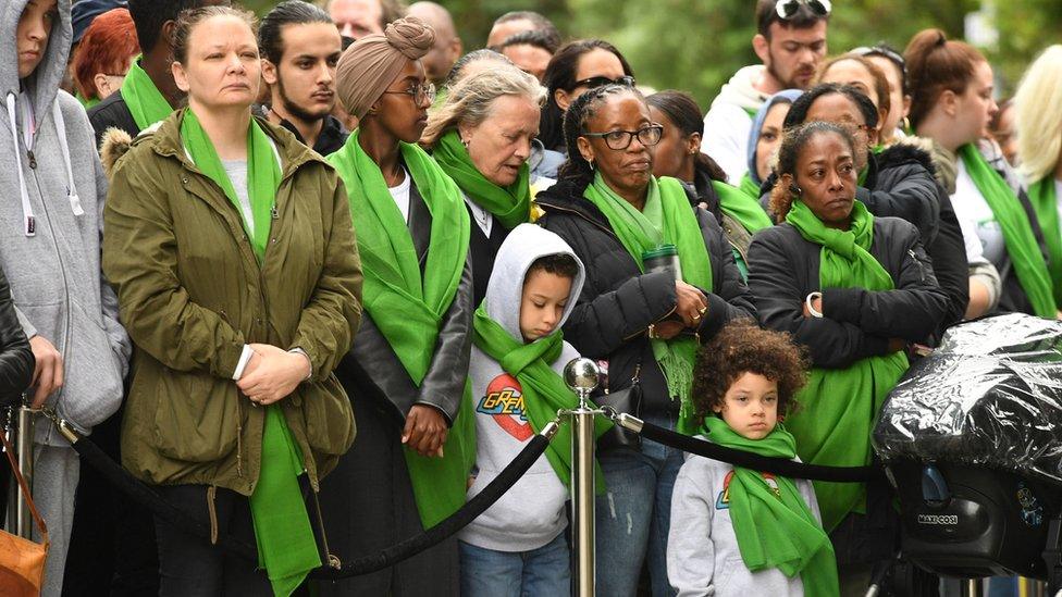 People gathered at a memorial near the tower