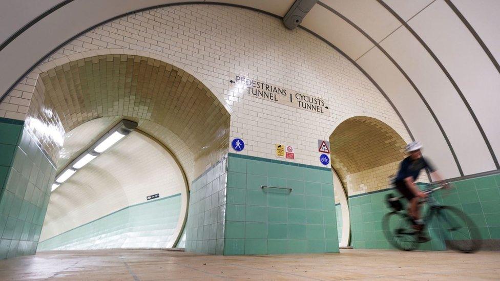 A cyclist rides through the reopened tunnel