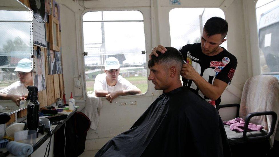 An inmate at work at the barber shop