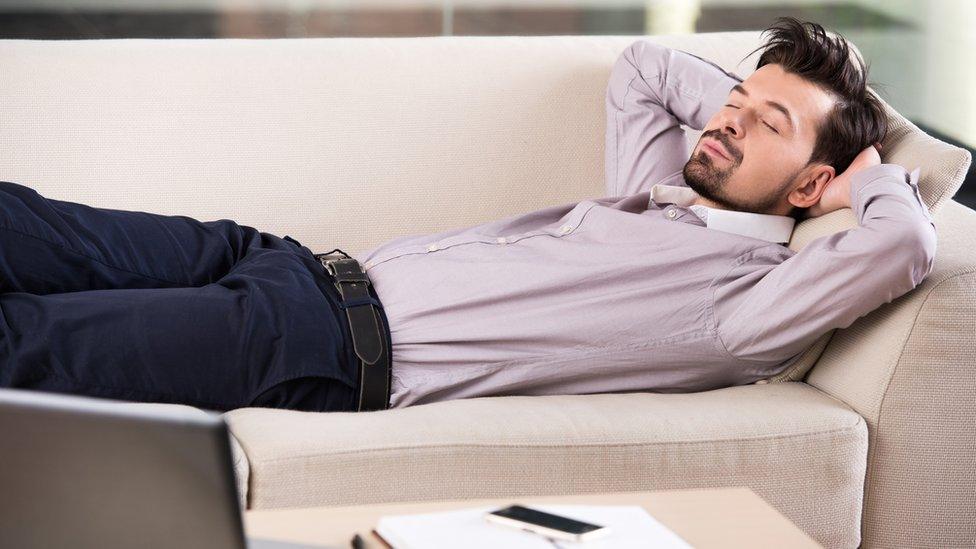 Businessman asleep on sofa